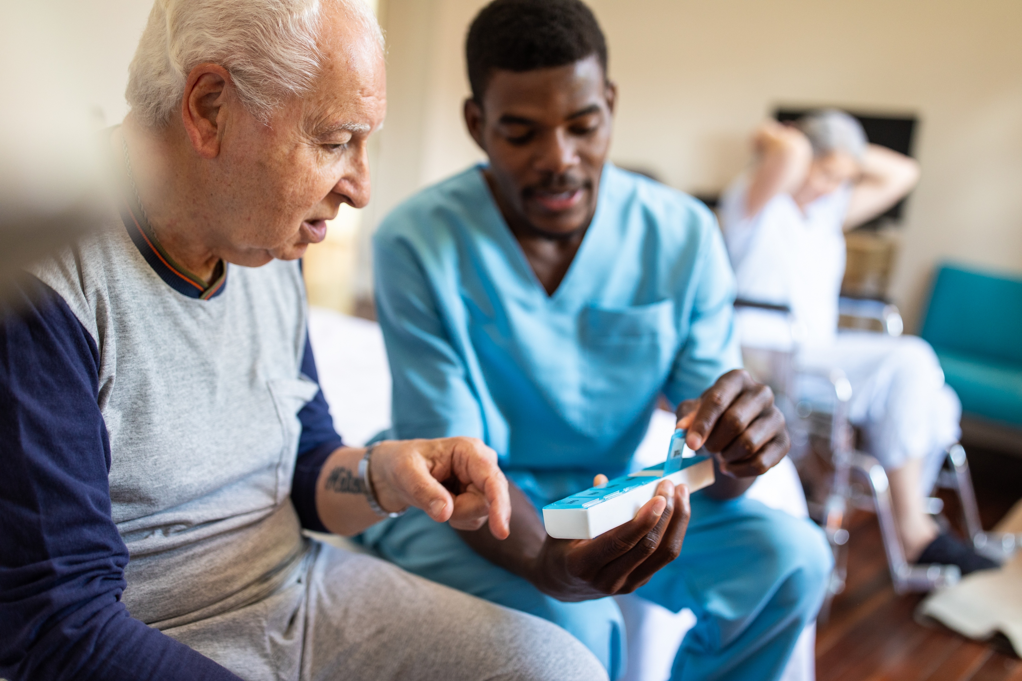 20230426_-_black_male_nurse_sitting_on_bed_and_giving_instructions_to_senior_patient_male_patient